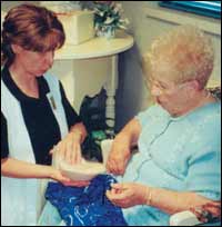 Patricia Metcalf, Orthotist/CMF, A Fitting Image, demonstrates placement of a breast form in a swimsuit to Mildred Holtz, mastectomy patient.