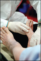 A practitioner examines the feet of a patient who has diabetes.