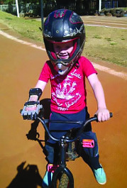 Boy with e-NABLE hand on bike