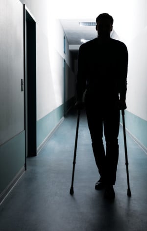 patient with crutches in hallway